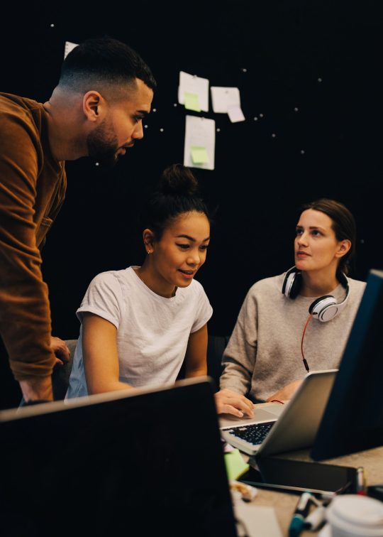 three people with a laptop