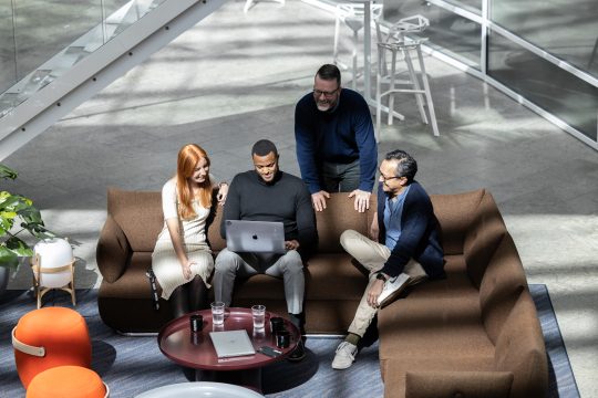 four people sitting in in a sofa